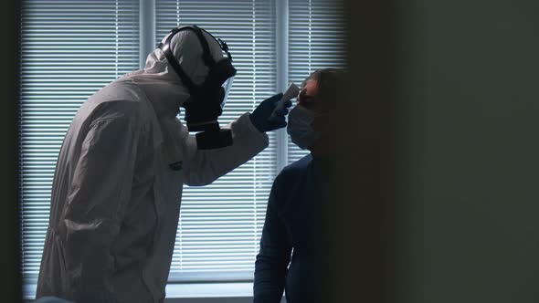 Paramedic Is Checking Man's Temperature with a Modern Device