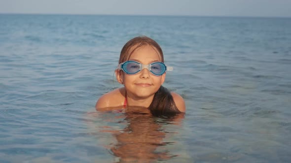 Portrait of Young Girl in Water Mask Relaxing in Sea Water. Child Enjoying Rest