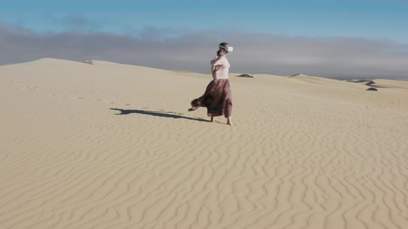 Girl Uses Virtual Augmented Reality Glasses in Magic Atmosphere of Summer Desert