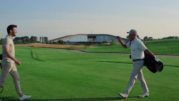 Golf Players Shaking Hands on Grass Field