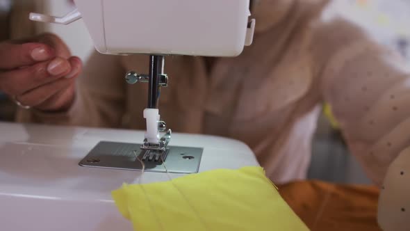 Mixed race woman sewing in fashion office