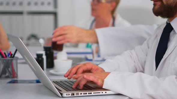 Man Doctor Using Laptop Writing Treatment Informations