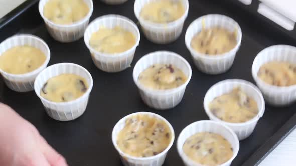 A Woman Settles The Dough In The Muffin Tins.