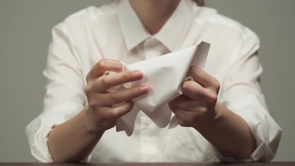 Young Woman Wearing White Shirt Crumpling a Paper Into Ball and Throwing Away