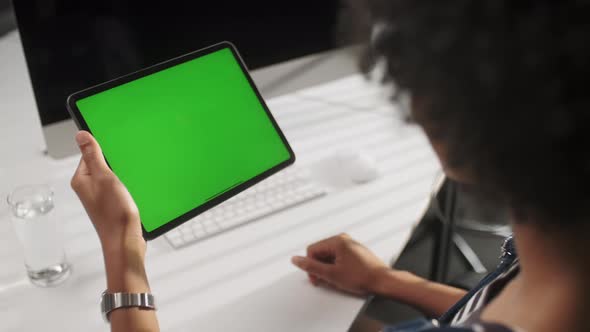 View From the Shoulder of Man Using Hand Gestures Swipe Up on Green Mock-up Screen Digital Tablet