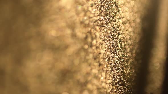 Beautiful Glitter of Floating Dust Particles on a Dark Background in Slow Motion