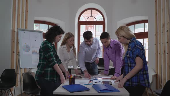 Diverse Team Discussing Project in Boardroom