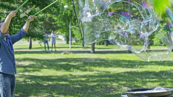 Little Boys Catching Huge Soap Bubble Made by Performer