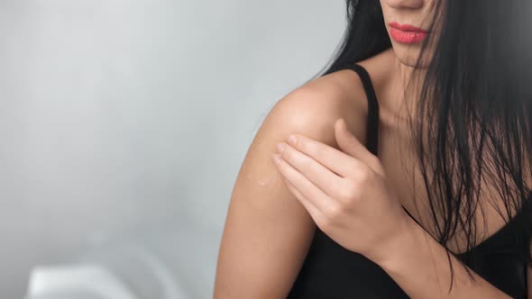 Close Up Seductive Woman Applying Moisturizing Cream on Body Skin