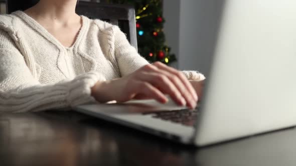 Woman working with laptop computer at home in Christmas time