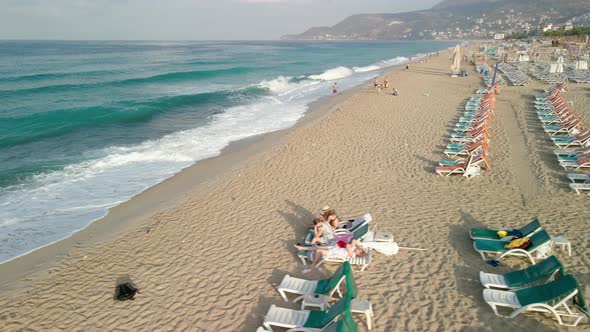 A Drone View of the Waves Crashing Against the Sandy Shore of the Beach