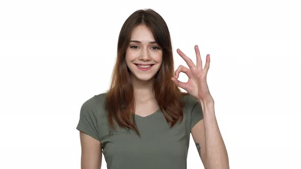 Portrait of Happy Woman 20s in Casual Clothing Smiling and Showing Alright Symbol with Fingers