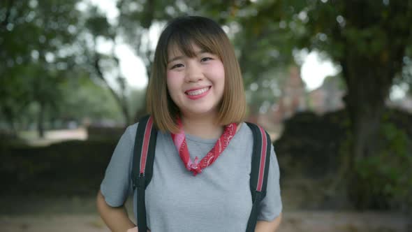 Asian woman feeling happy smiling to camera holiday trip at Ayutthaya, Thailand, backpacker enjoy