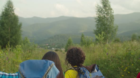 Joyful Diverse Multiracial Backpackers Relaxing on Mountain Top During Hiking