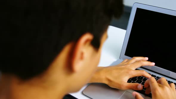 Students using digital tablet and laptop in classroom