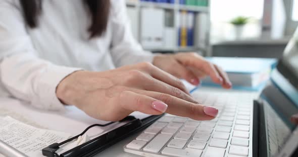 Woman is Typing on Laptop Keyboard Closeup