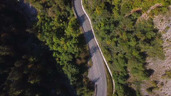 Aerial overhead view of a mountain road. French Alps in autumn. Car passing by.