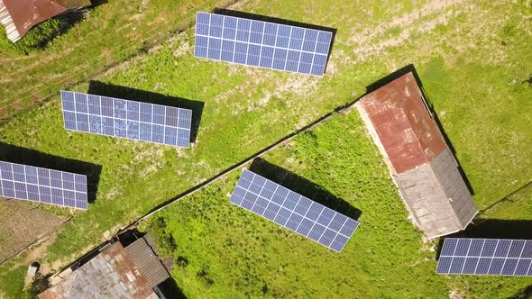 Aerial top down view of solar panels in green rural area.