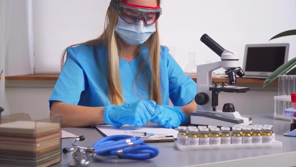 Woman Laboratory Worker Fills in the Syringe with Experimental Drug From Vial