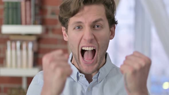 Portrait of Young Man Celebrating Success With Fest