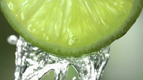 Slow Motion Macro Shot of Flowing Lime Juice From Lime Slice