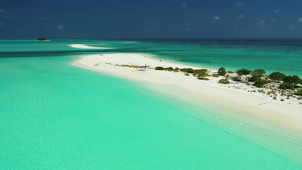 White uninhabited island, sandbank in the emerald sea water. Aerial background