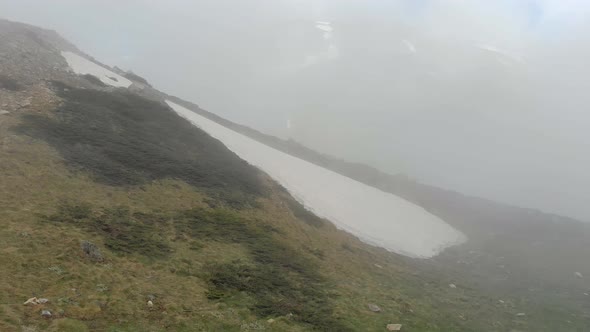 Piece of Snow on the Mountain Slope In Fog