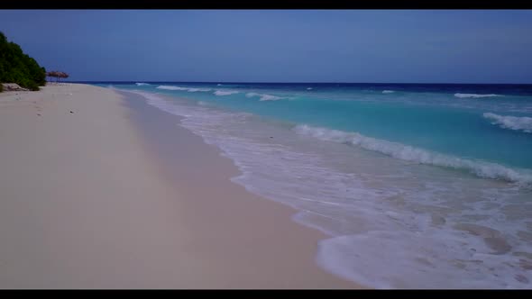 Aerial flying over scenery of relaxing island beach adventure by turquoise lagoon with white sandy b