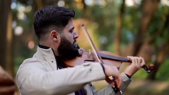 Adult Bearded Man is Playing Fiddle in Forest Romantic Musician with Violin in Nature