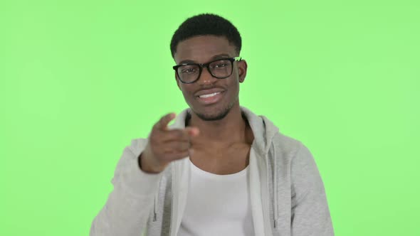 African Man Inviting People on Green Background