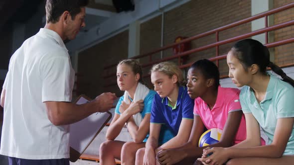 Volleyball coach talking to female players 4k