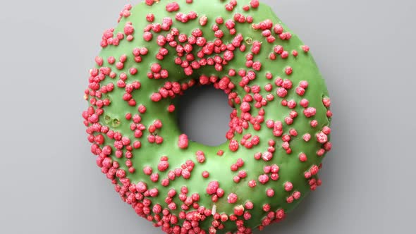 Fresh Delicious Doughnut Covered By Bright Pastry Confectionery Topping and Green Chocolate Icing