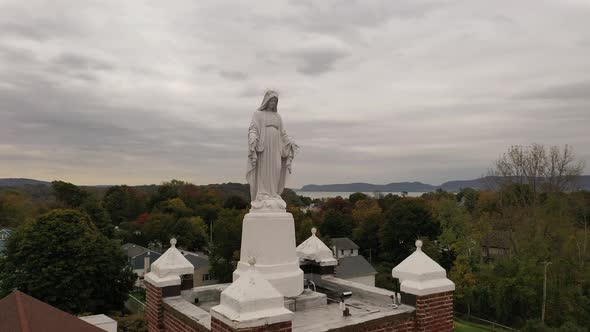 An aerial view of a statue of the Virgin Mary on a Catholic Church in upstate, NY. The drone camera