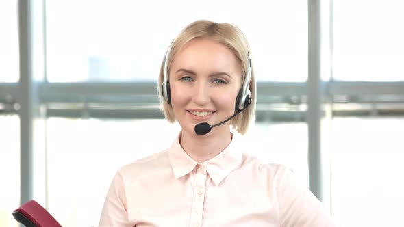 Blond Woman with Headset Showing Thumb Up.