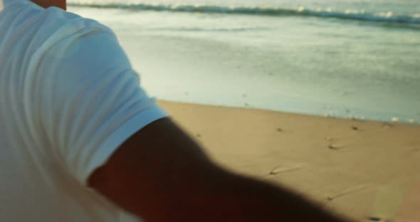 Senior man shielding eyes on beach