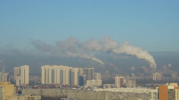 City Pipes Emit Steam Into the Atmosphere Against the City Skyline 6