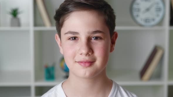 Portrait of Happy Boy of 1213 Years Old in White Shirt Looking at Camera and Smiling at Home