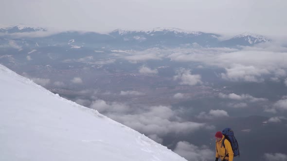 A Traveler Climbs the Snowy Slope of the Mountain
