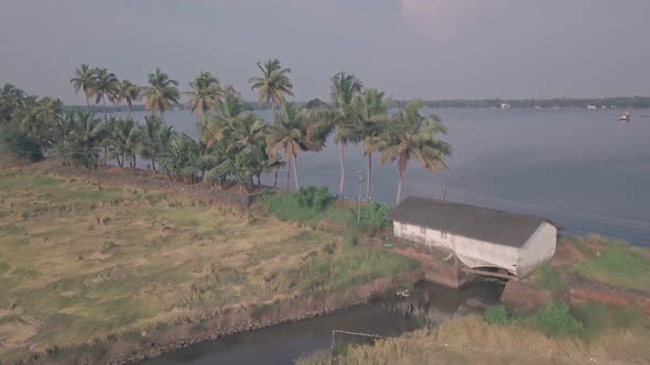 Kerala backwaters scenery of palm trees, fields and lake in India. Aerial drone view