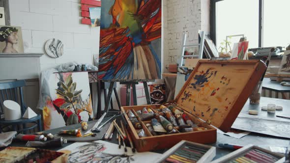 Art Supplies and Abstract Painting on Easel in Studio
