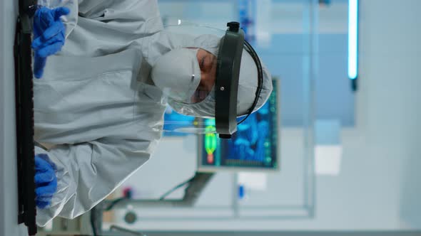 Vertical Video Scientist in Coverall Examining Blood Test Tubes at Laboratory DNA Testing Analysis