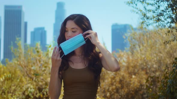 Girl Covering Face with Mask in Park Closeup