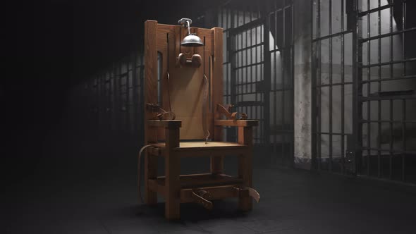 Wooden electric chair in the spotlight in a prison block. Vertigo shot. 4K HD