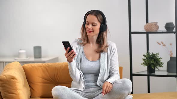 Lady Listening Music in Headphones Use Smartphone Dancing Relaxing at Home