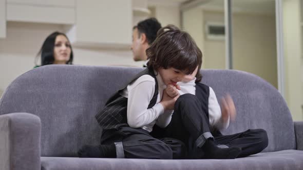 Playful Cheerful Twin Brothers Rejoicing Supporting Sports Team Watching TV with Parents Talking at