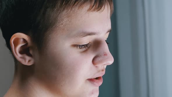 Closeup of a Face Profile of Talking Smiling Teenager Looking Down