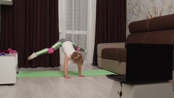 Children Girl Watching Online Distance Lessons with Trainer on Laptop Exercising Twine at Home