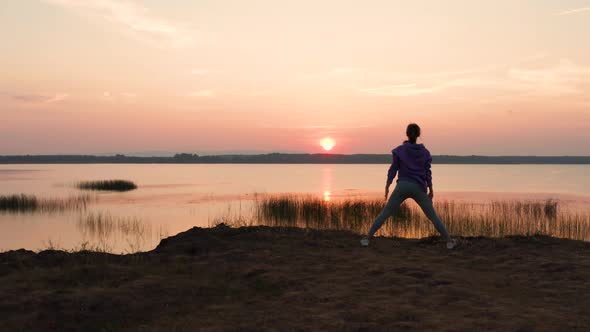 A Girl Does Fitness on a Hill at Sunset