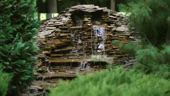 A small decorative waterfall in the  garden. Landscape design