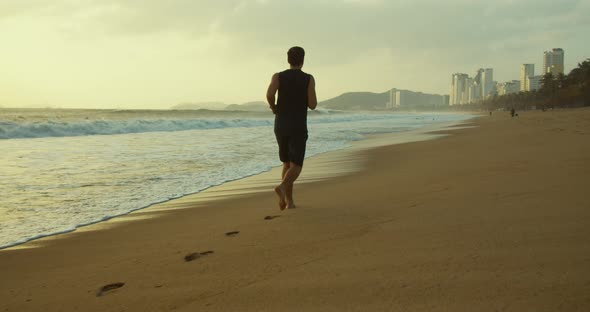 Young Caucasin Man Are Exercising with Outdoor Running with a Beautiful Sea Background